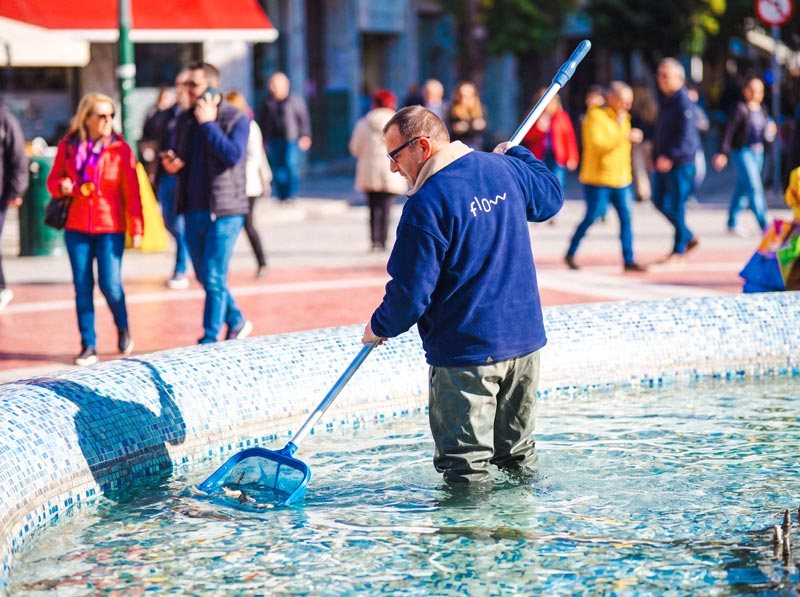 Τεχνικός της Flow καθαρίζει σιντριβάνι, απομακρύνοντας φερτά υλικά με απόχη